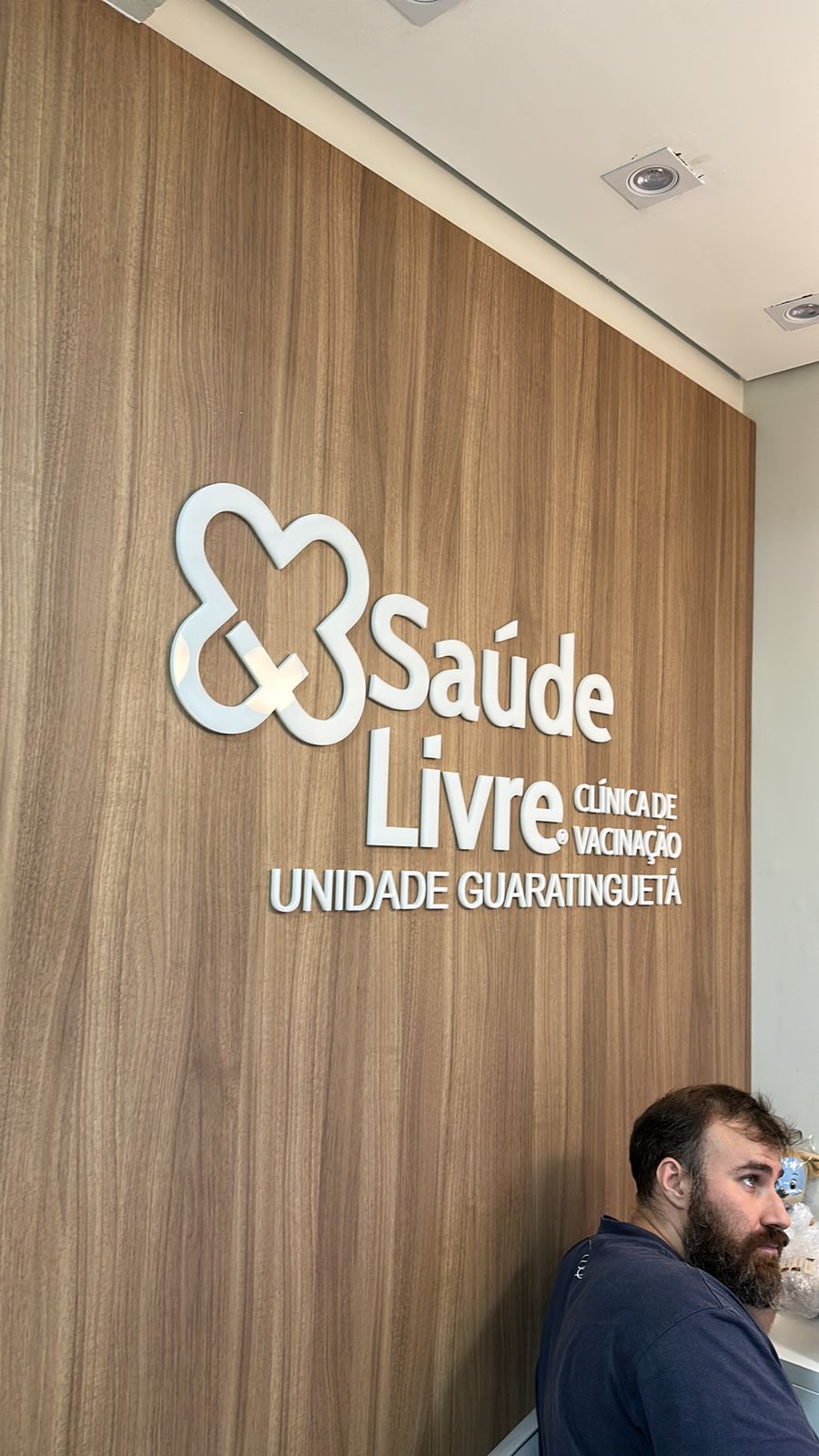 Logotipo Saúde Livre na parede de madeira da unidade Guaratinguetá