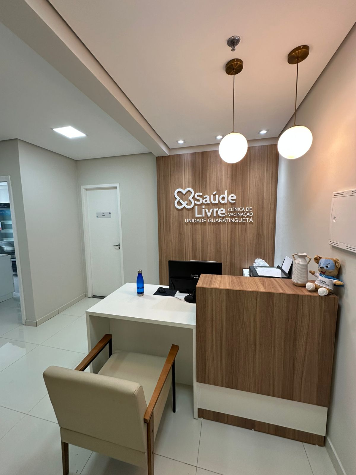 Recepção da Saúde Livre Guaratinguetá com balcão de atendimento e marca na parede
